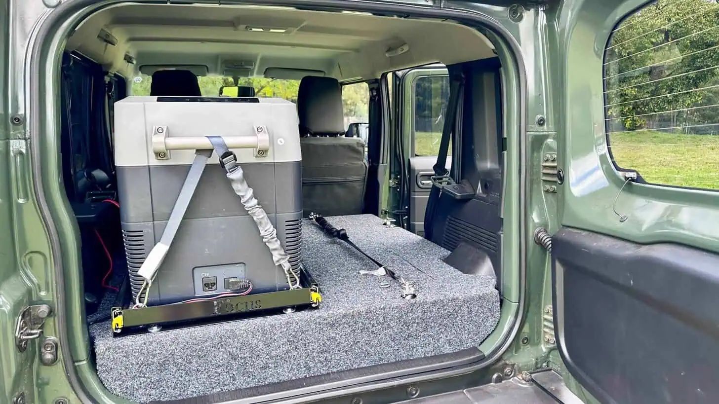 The boot of a Suzuki Jimny 5-door loaded with a slide-out fridge on a drawer system