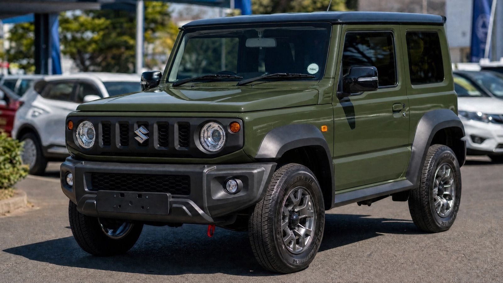 A clean used green Suzuki Jimny 3-door on a dealership forecourt in South Africa