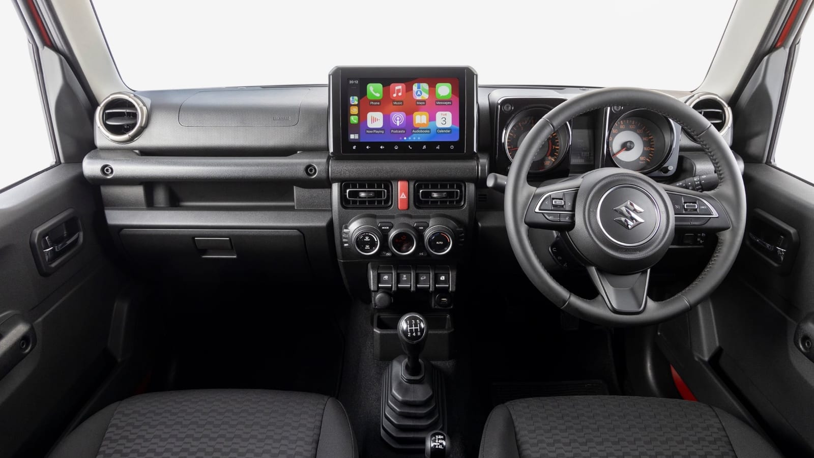 The dashboard of a Suzuki Jimny 5-door GLX with a manual gear lever and a 9-inch touchscreen showing Apple CarPlay